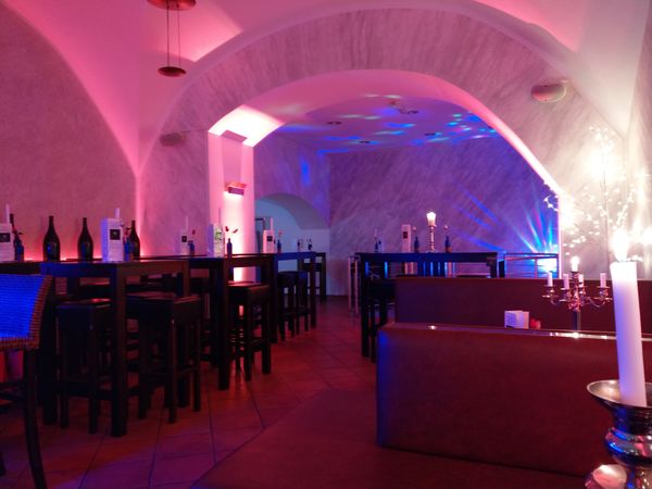 Bar oben: Gewölbe mit Kerzenlicht und Stehtischen