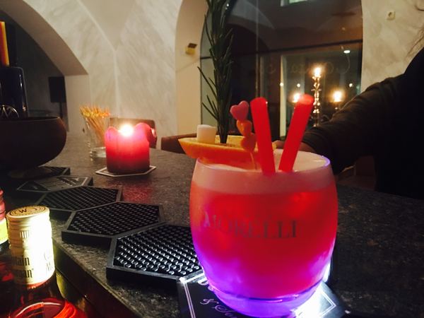 Roter Cocktail neben Kerze