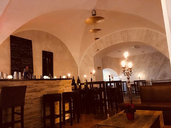 Weißes Gewölbe mit Kronleuchter und Bar